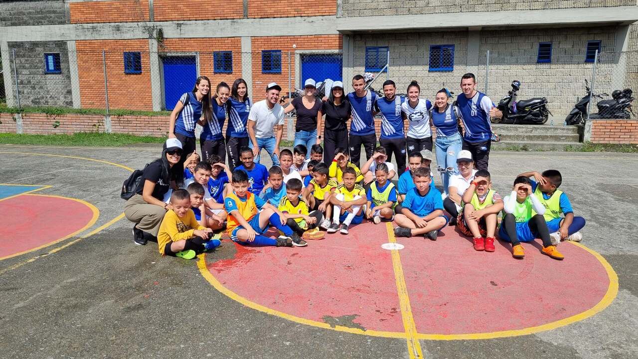 Alpha FC participants, coaches, and community members together on a fútbol sala court