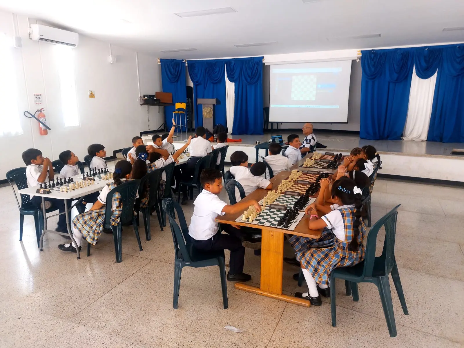 Estudiantes reunidos alrededor de tableros de ajedrez durante una sesión escolar en Santa Marta