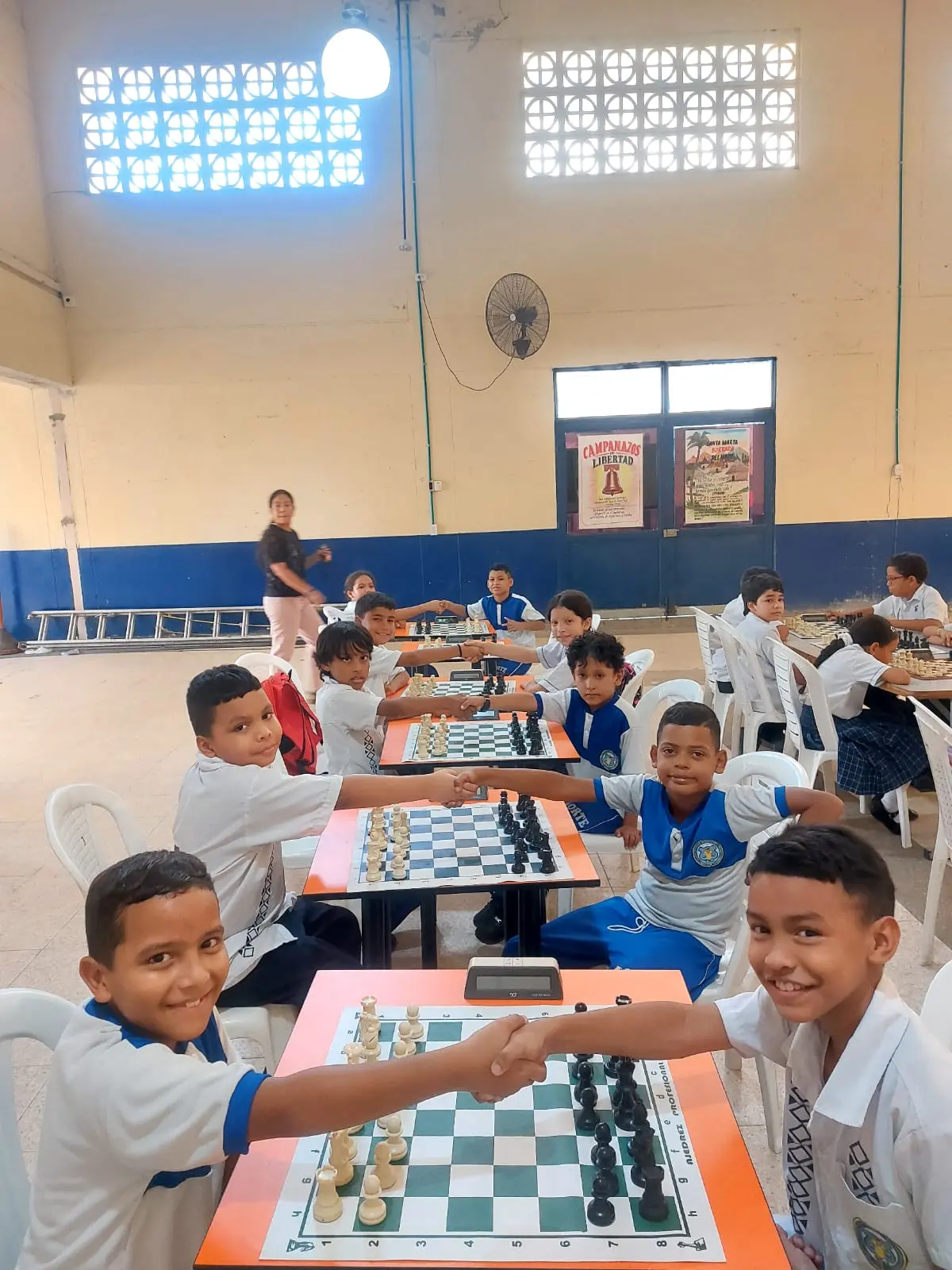Estudiantes se saludan sobre los tableros durante una sesión escolar en Santa Marta